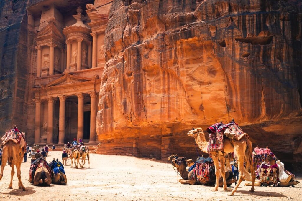 The Treasury at Petra, Jordan, an ancient rock-cut temple with intricate carvings, surrounded by towering rose-red cliffs.