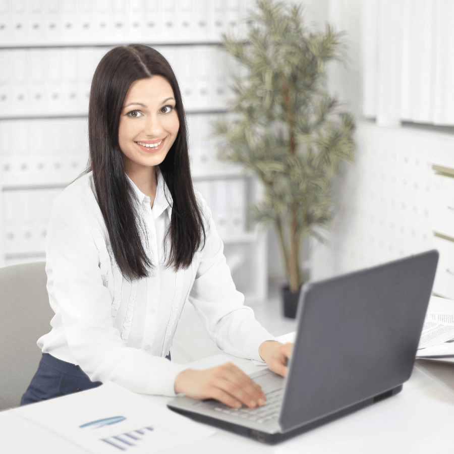 A person working at a desk with a laptop, representing a typical virtual assistant setup.