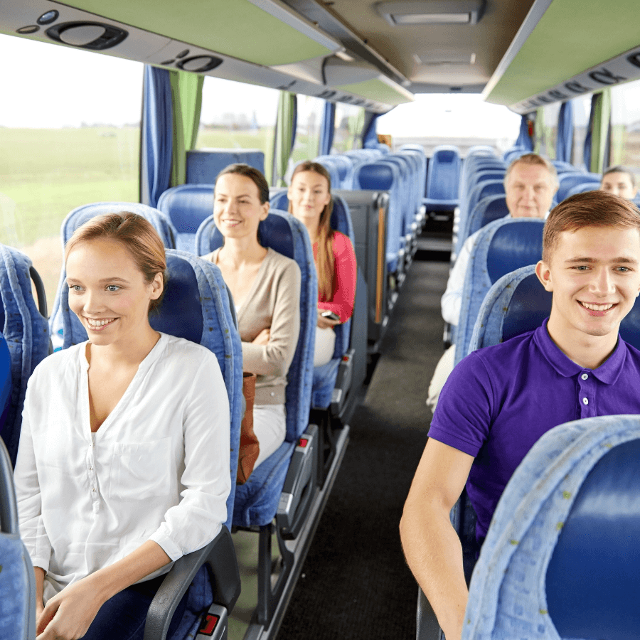 Interior view of a busy public transportation bus with passengers seated and standing.