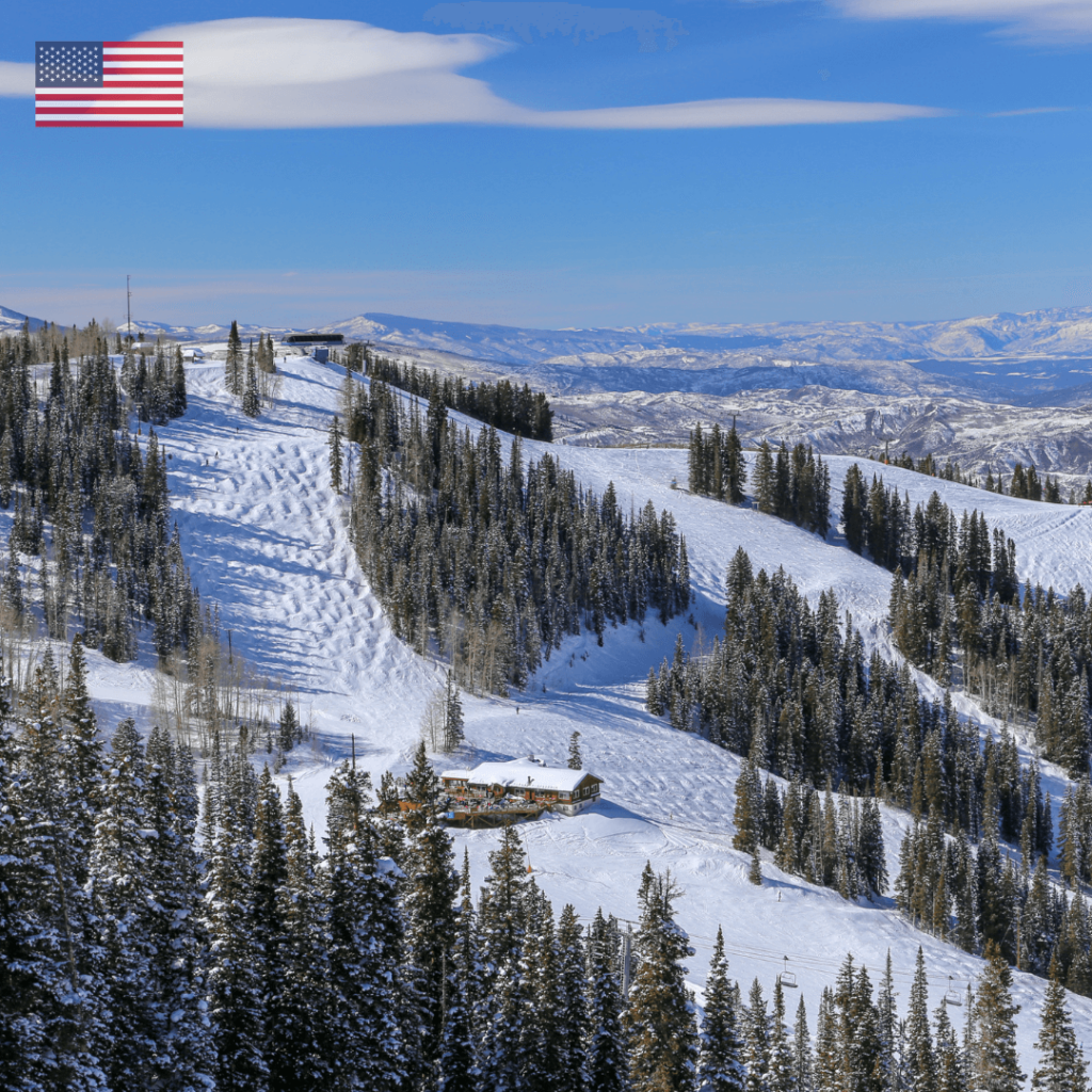 A winter destination in Aspen, Colorado, USA, featuring snow-covered mountains, ski slopes, and a cozy mountain lodge, set against a clear blue sky.