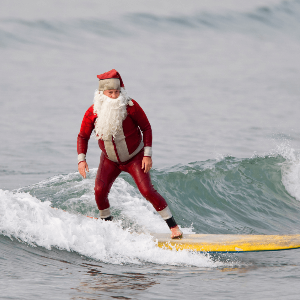 Santa Claus enjoying a beach day in Australia, with sunbathing, surfing, and festive decorations by the sea.