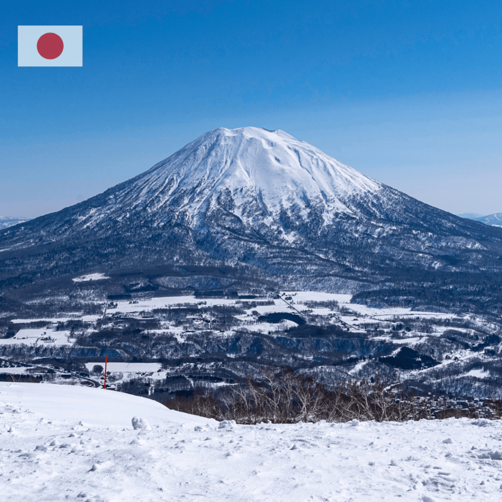 A snowy winter scene in Niseko, Japan, featuring snow-covered mountains, ski slopes, and a cozy village nestled in the valley, known for its world-class skiing and powder snow