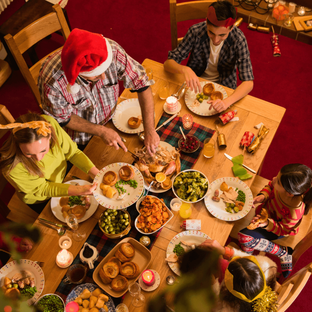 Festive Christmas dinner with people gathered around a beautifully decorated table enjoying a holiday meal.