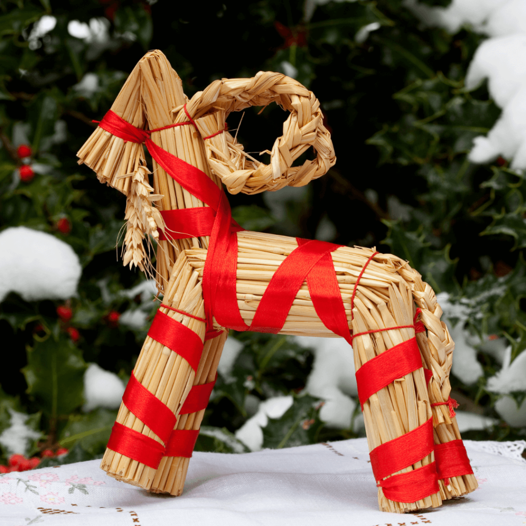 A large straw Yule Goat, traditionally made for Christmas in Sweden, standing in a town square, with festive lights and decorations, symbolizing holiday cheer with a hint of its fiery reputation