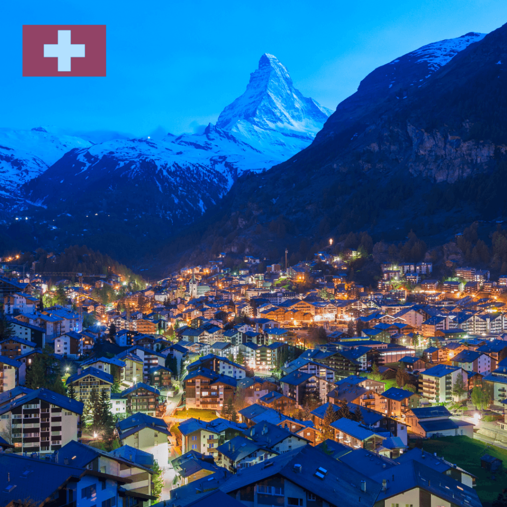 Picturesque view of Zermatt, a charming Swiss town nestled in a valley with the iconic Matterhorn mountain in the background, illuminated at dawn or dusk